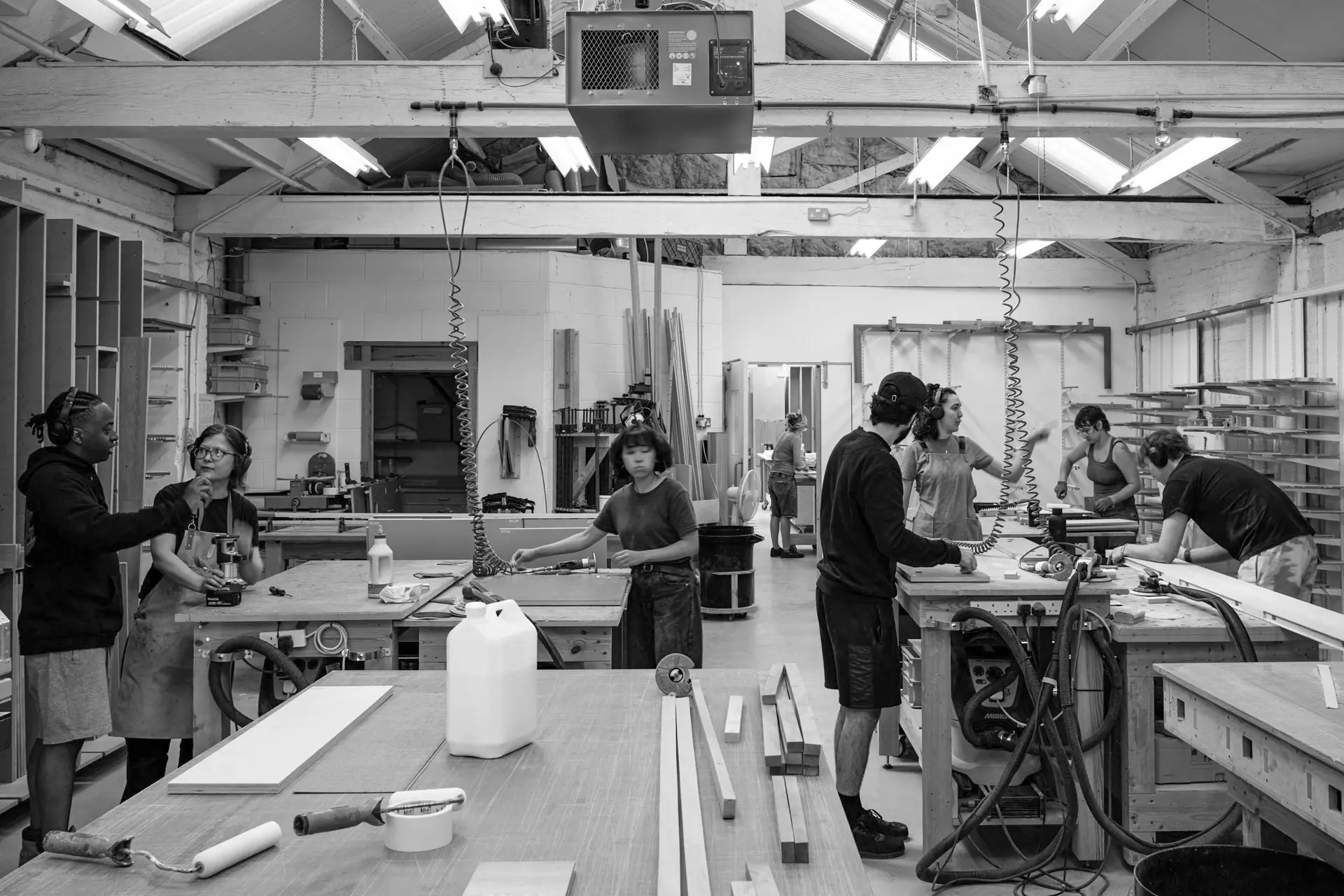 Busy workshop scene with numerous workbenches and cabinetmakers.