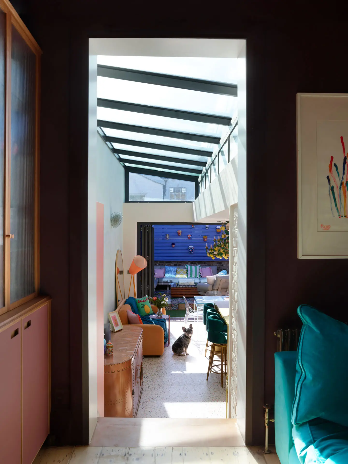 Raspberry and London Plane glass cabinets in a snug, alongside a coral pink Pluck kitchen.