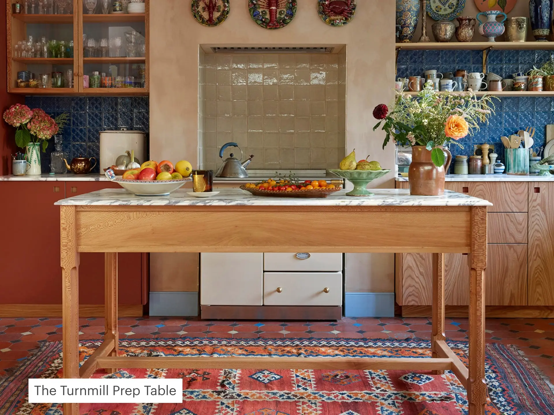 Pluck kitchen with a prep table, colourful cabinets with marble worktops.