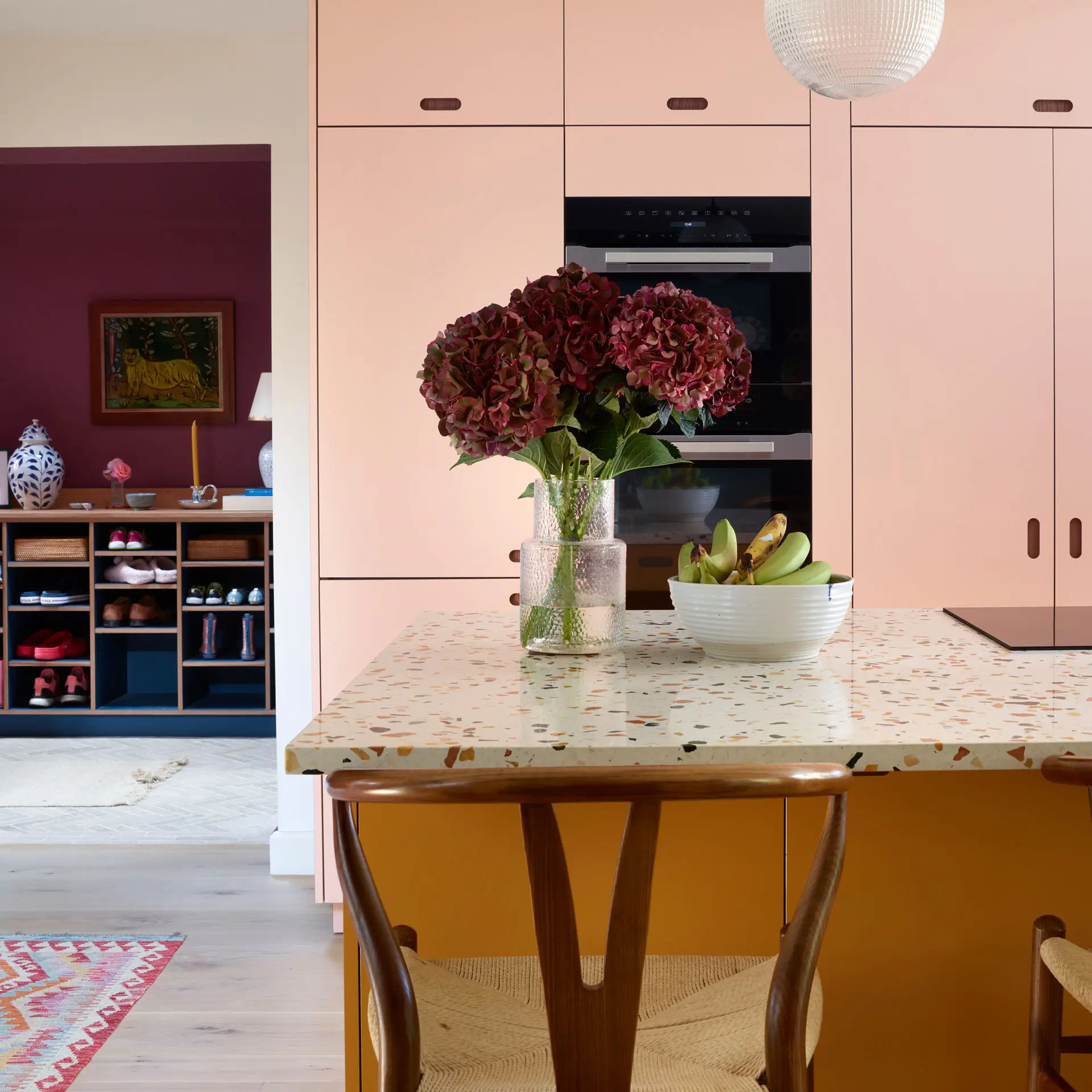 Pluck-Kitchens-Journal-The-Harpenden-Family-Kitchen-SQ-3 Colourful family kitchen in Hertfordshire including soft pink and mustard yellow Pluck cabinets, a large island and navy blue walls.