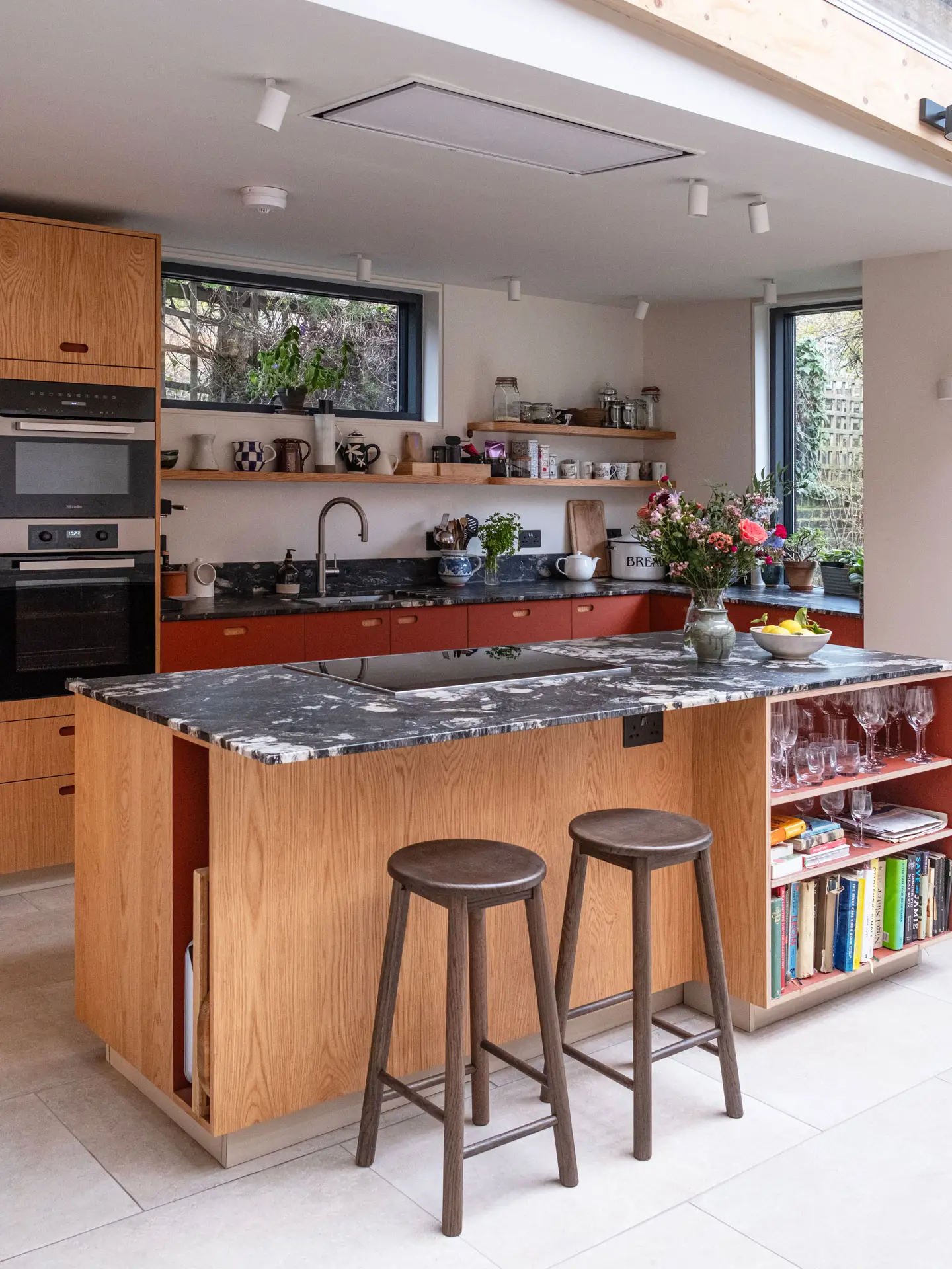 A Pluck kitchen in Kentish Town with oak and terracotta cabinetry including an island and shelving.