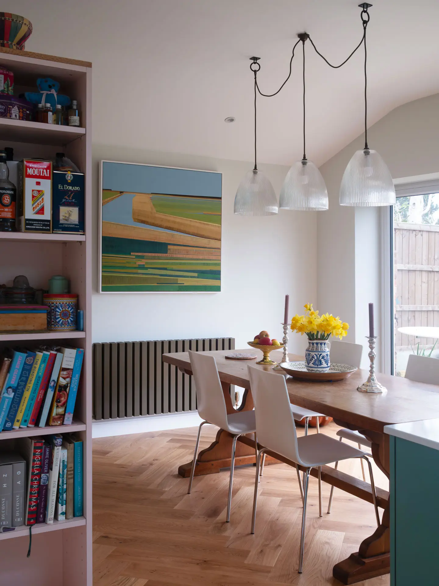 A kitchen in Greenwich, London, with Blue Green cabinetry by Pluck, white worktops, parquet flooring and art from around the world.