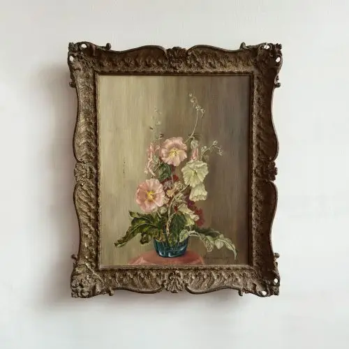 An oil painting with a vase of tumbling hollyhocks sits against an ombre backdrop