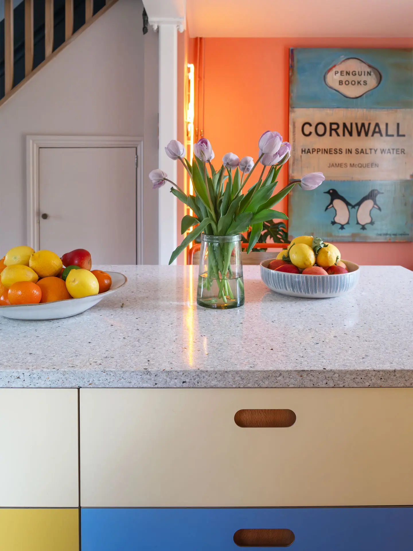 A colourful countryside kitchen with a bright yellow AGA and Pluck cabinetry, including an island.