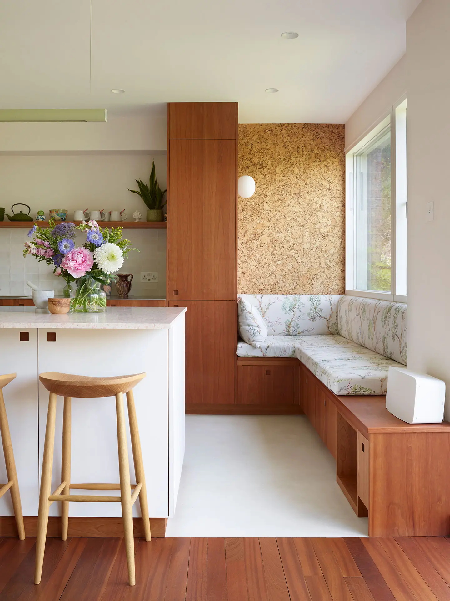 A Pluck kitchen in London with white and cherry wood custom cabinetry and a soft pink utility.