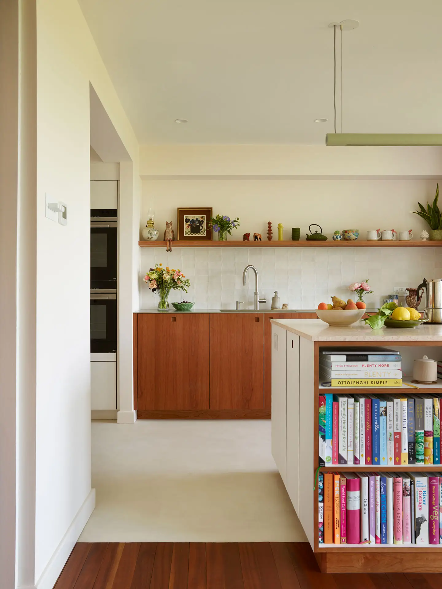 A Pluck kitchen in London with white and cherry wood custom cabinetry and a soft pink utility.