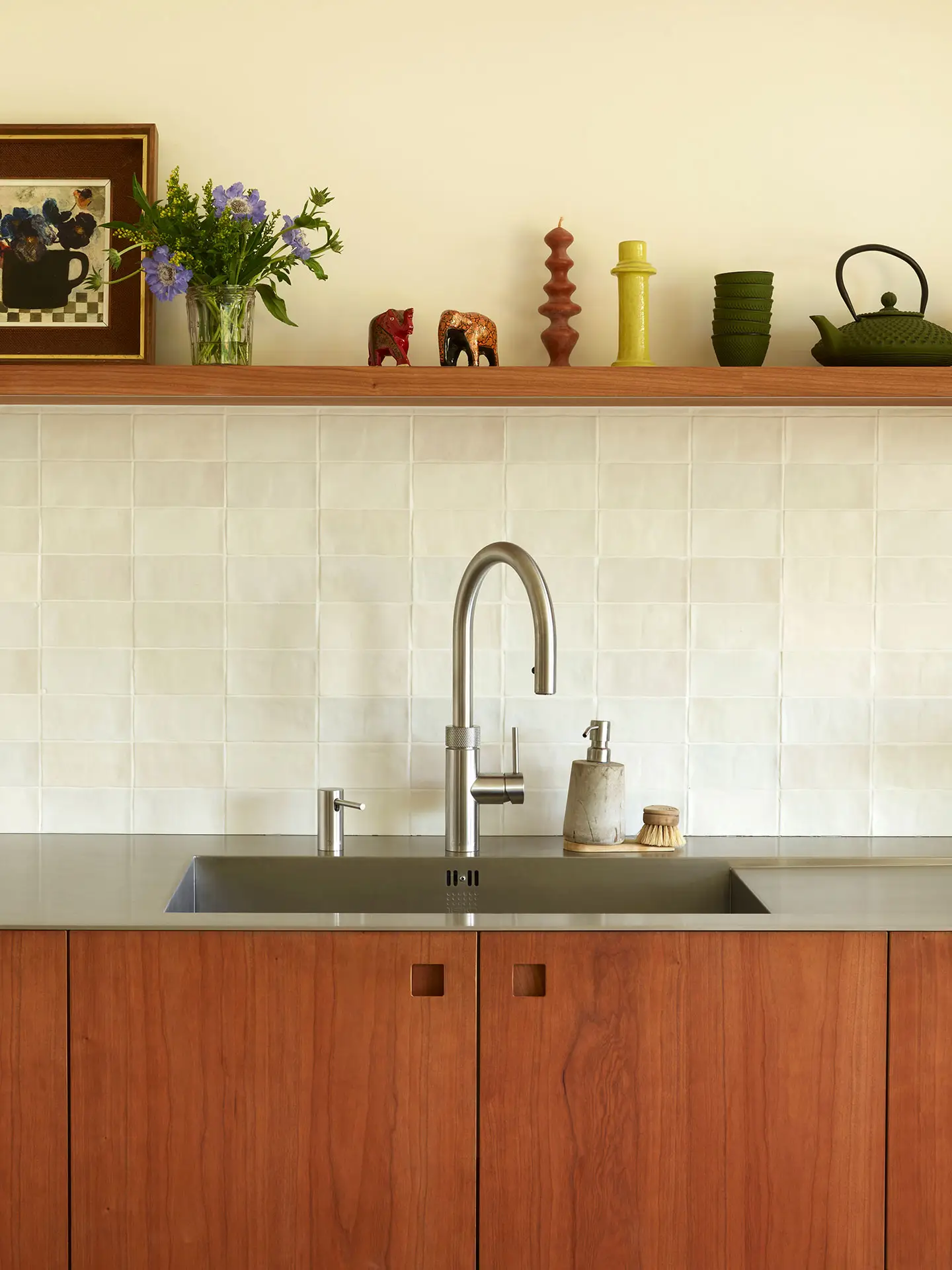 A Pluck kitchen in London with white and cherry wood custom cabinetry and a soft pink utility.
