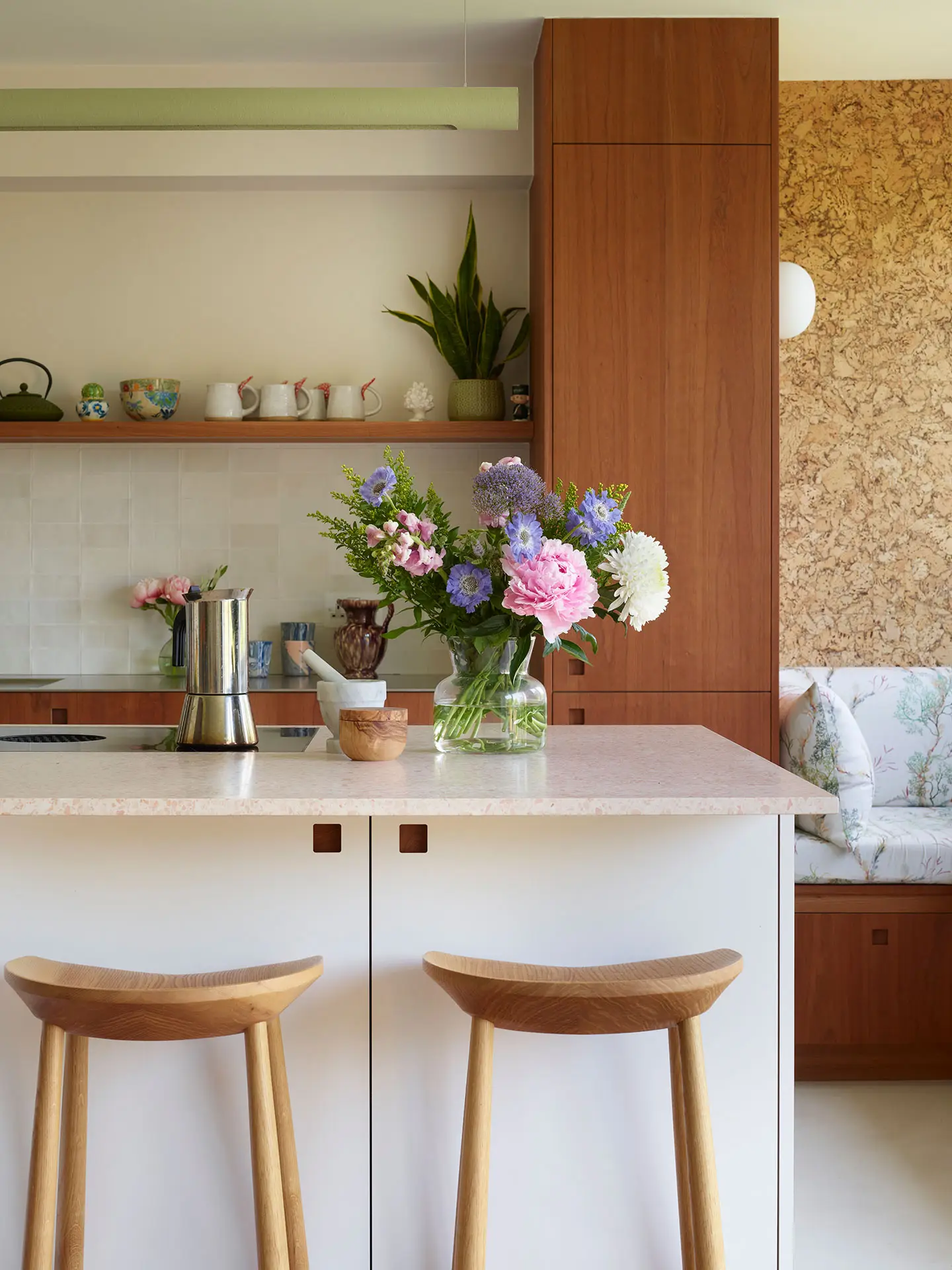 A Pluck kitchen in London with white and cherry wood custom cabinetry and a soft pink utility.