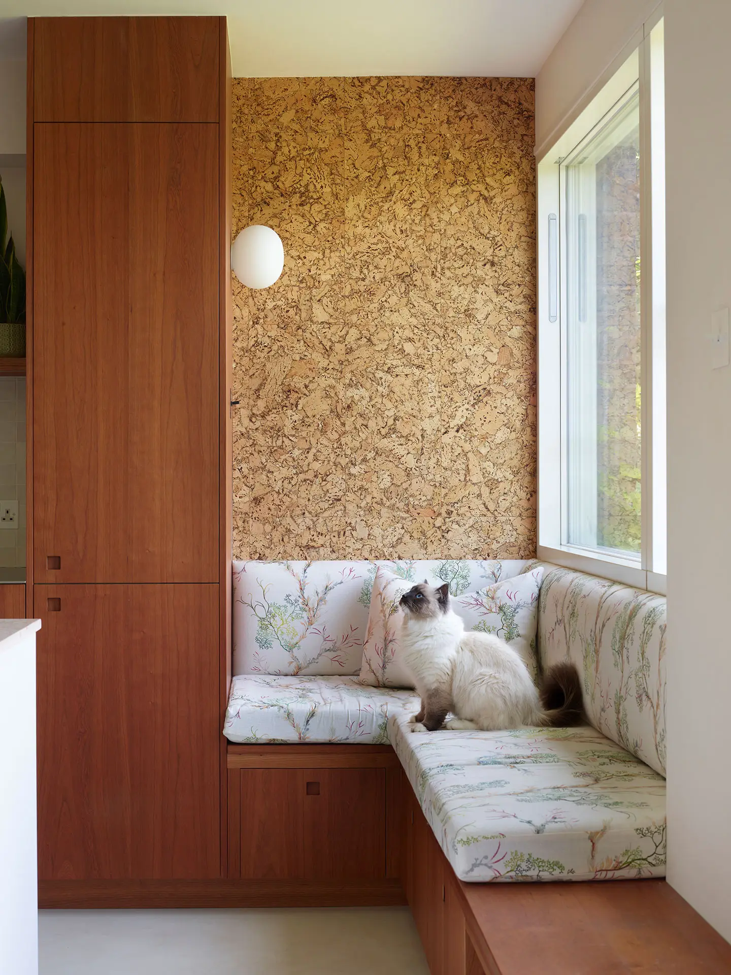 A Pluck kitchen in London with white and cherry wood custom cabinetry and a soft pink utility.