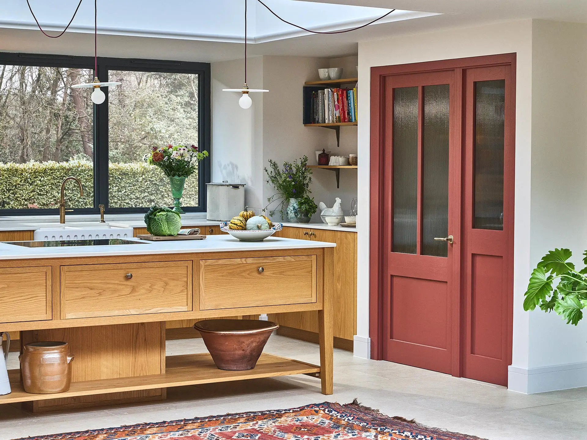 A family home in Surrey with oak wood Pluck cabinetry including a cook's table and a custom pantry cupboard.