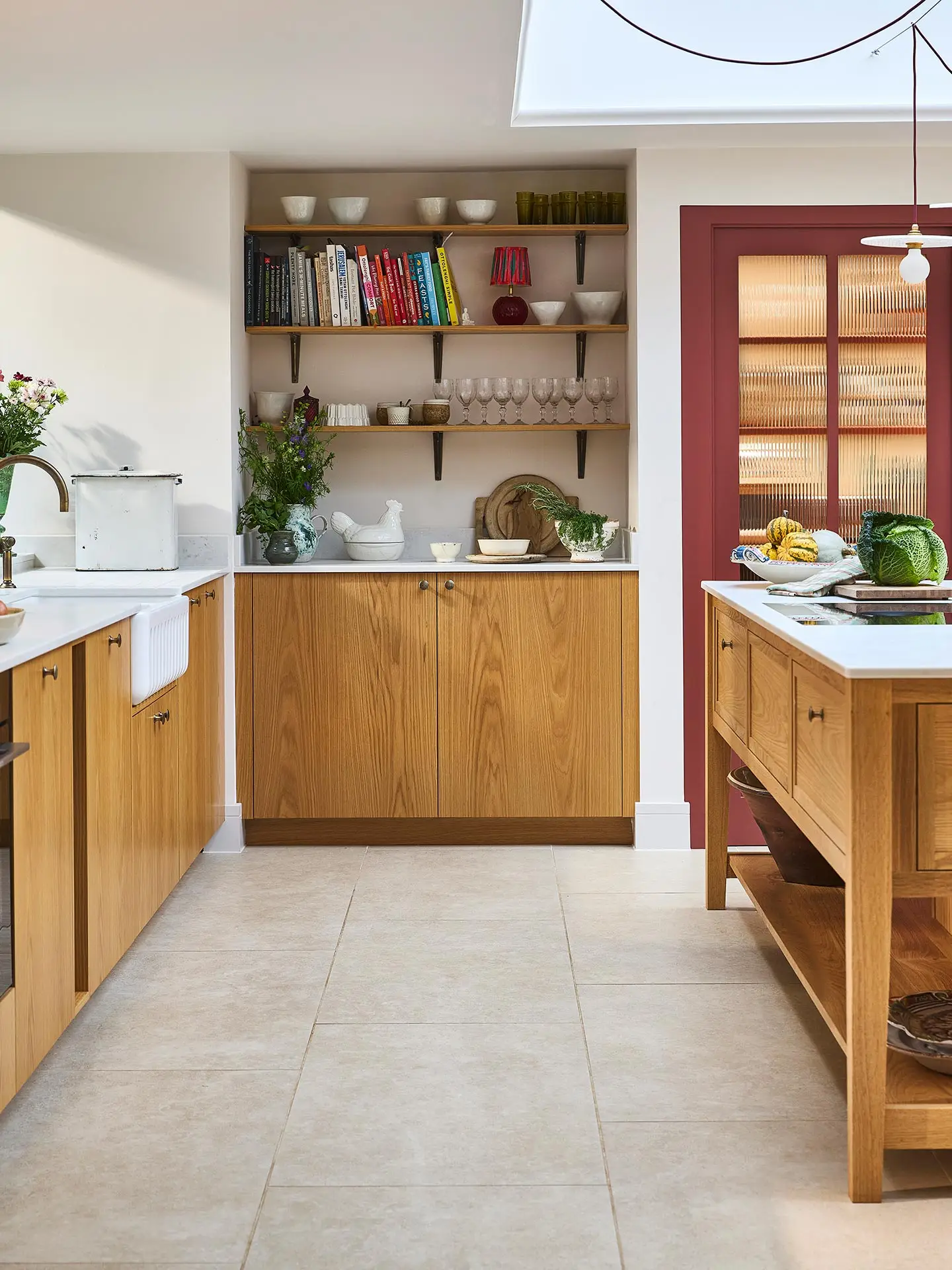 A large open plan kitchen with oak cabinets and a large central cook's table in a Surrey countryside family home.