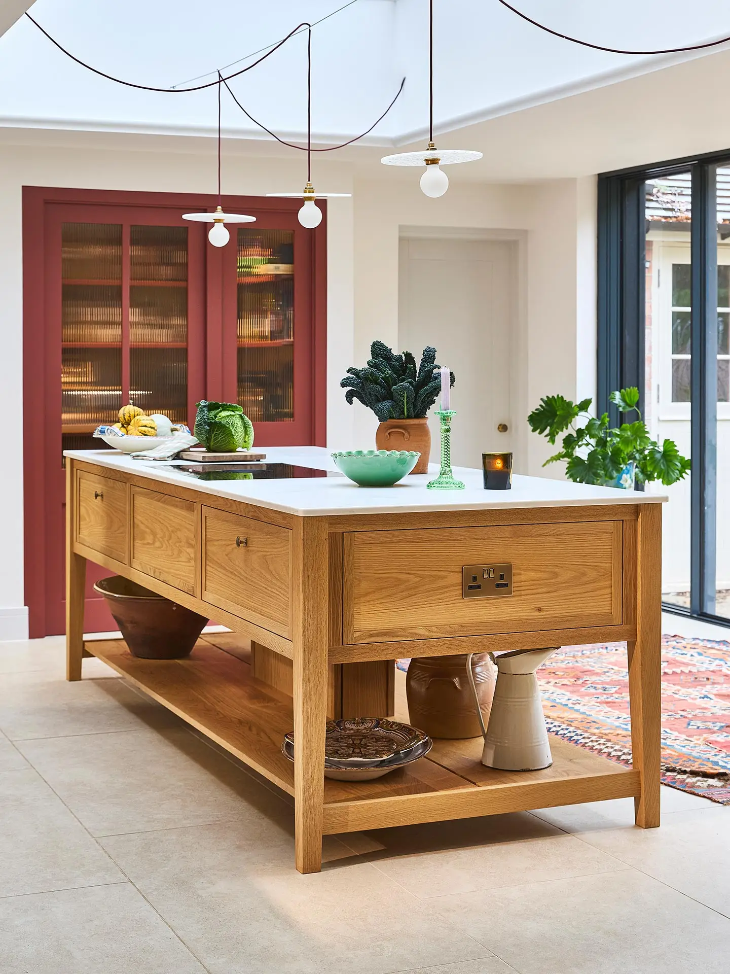 A family home in Surrey with oak wood Pluck cabinetry including a cook's table and a custom pantry cupboard.
