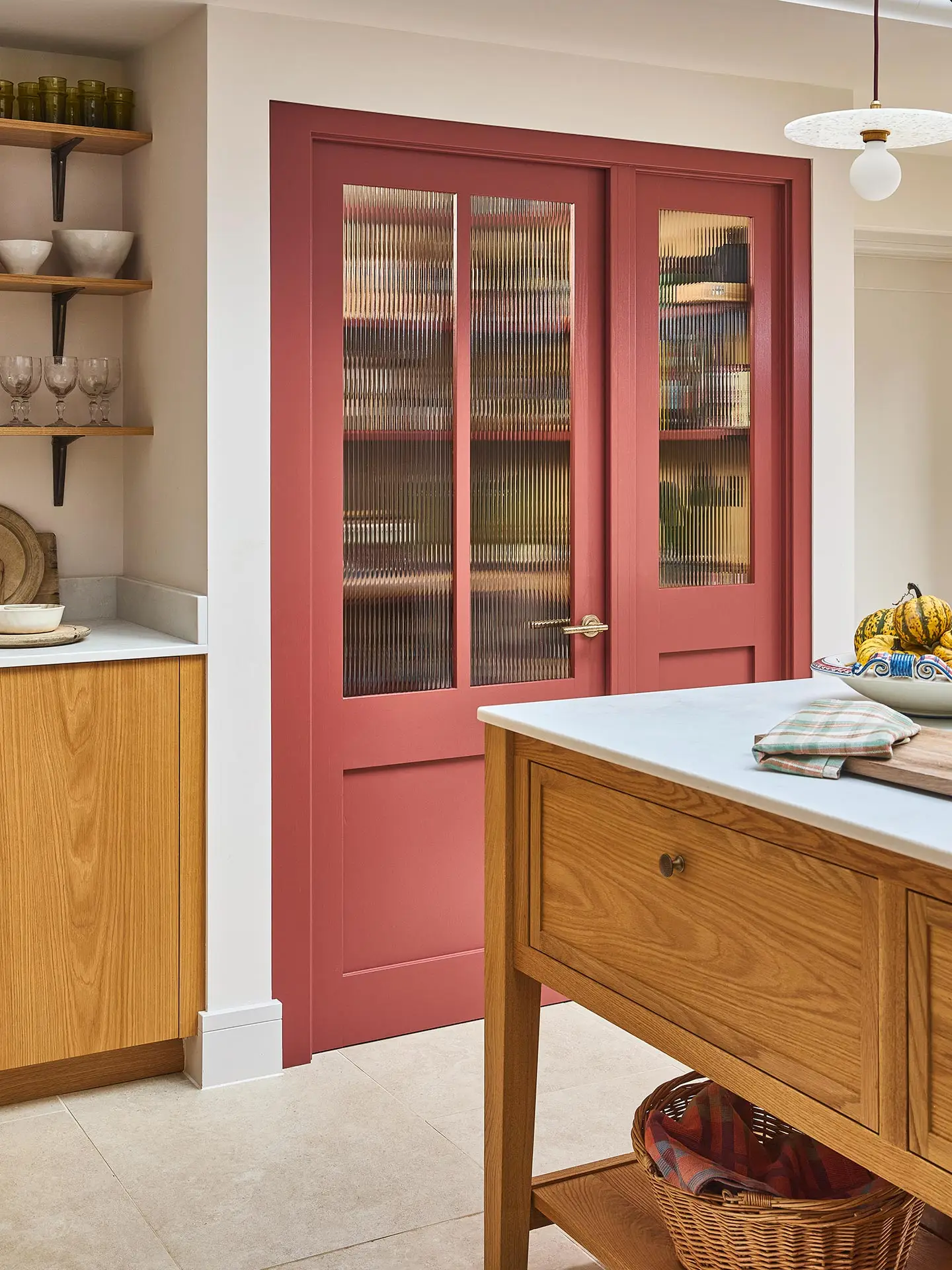 A large open plan kitchen with oak cabinets and a large central cook's table in a Surrey countryside family home.