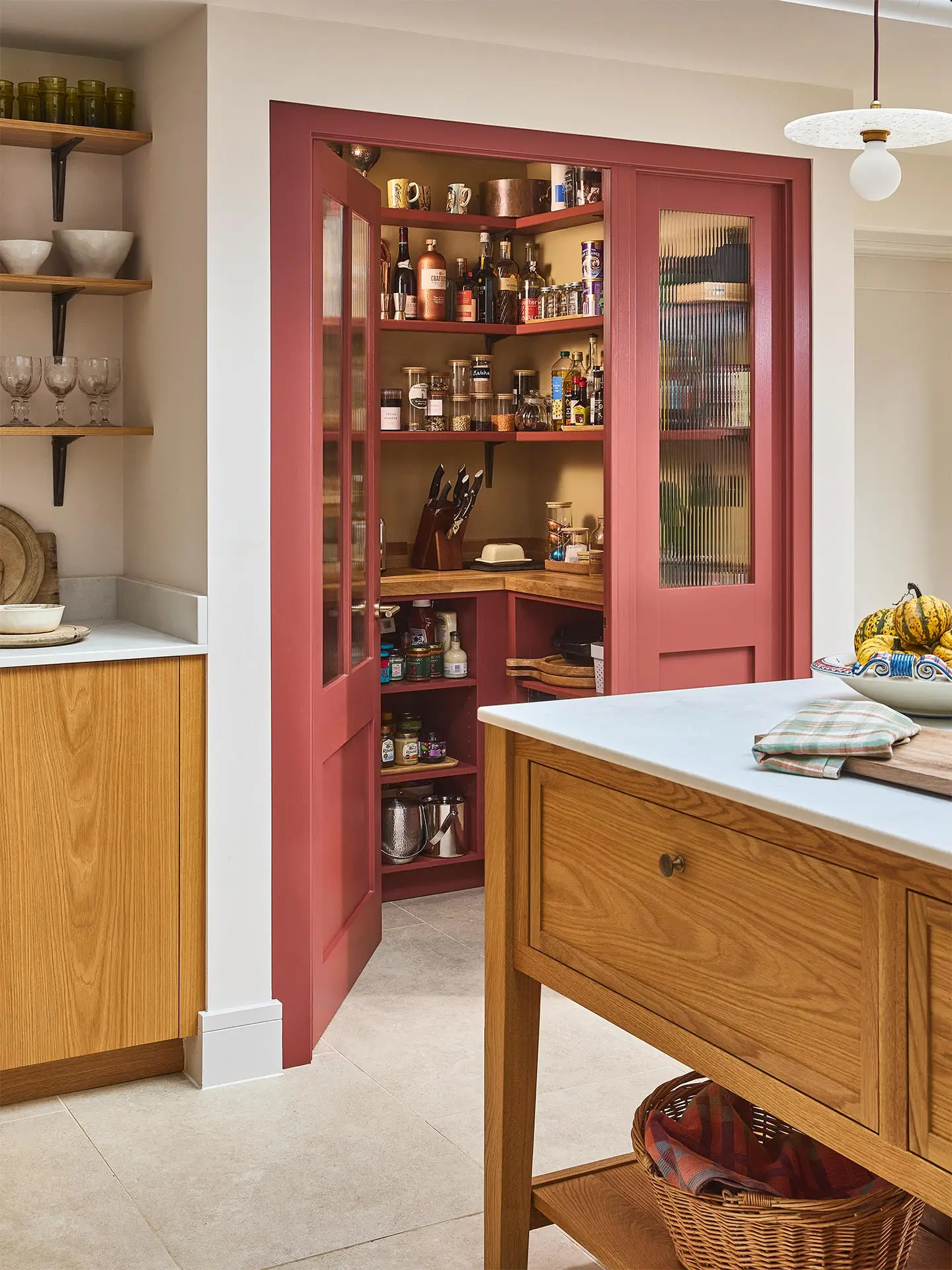 A large open plan kitchen with oak cabinets and a large central cook's table in a Surrey countryside family home.