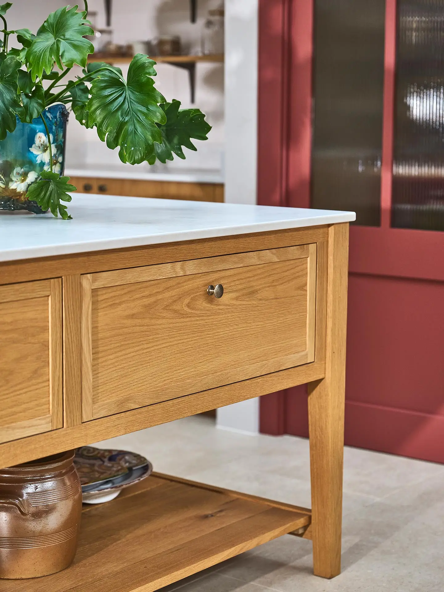 A family home in Surrey with oak wood Pluck cabinetry including a cook's table and a custom pantry cupboard.