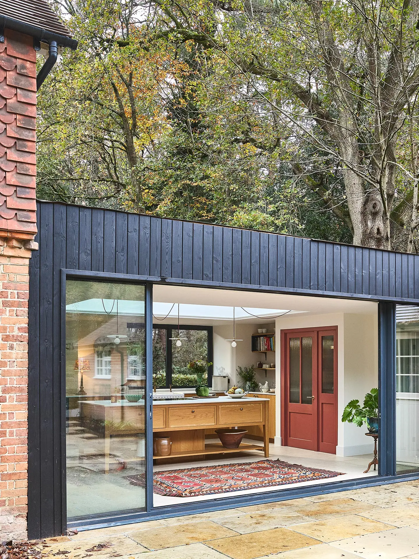 A family home in Surrey with oak wood Pluck cabinetry including a cook's table and a custom pantry cupboard.