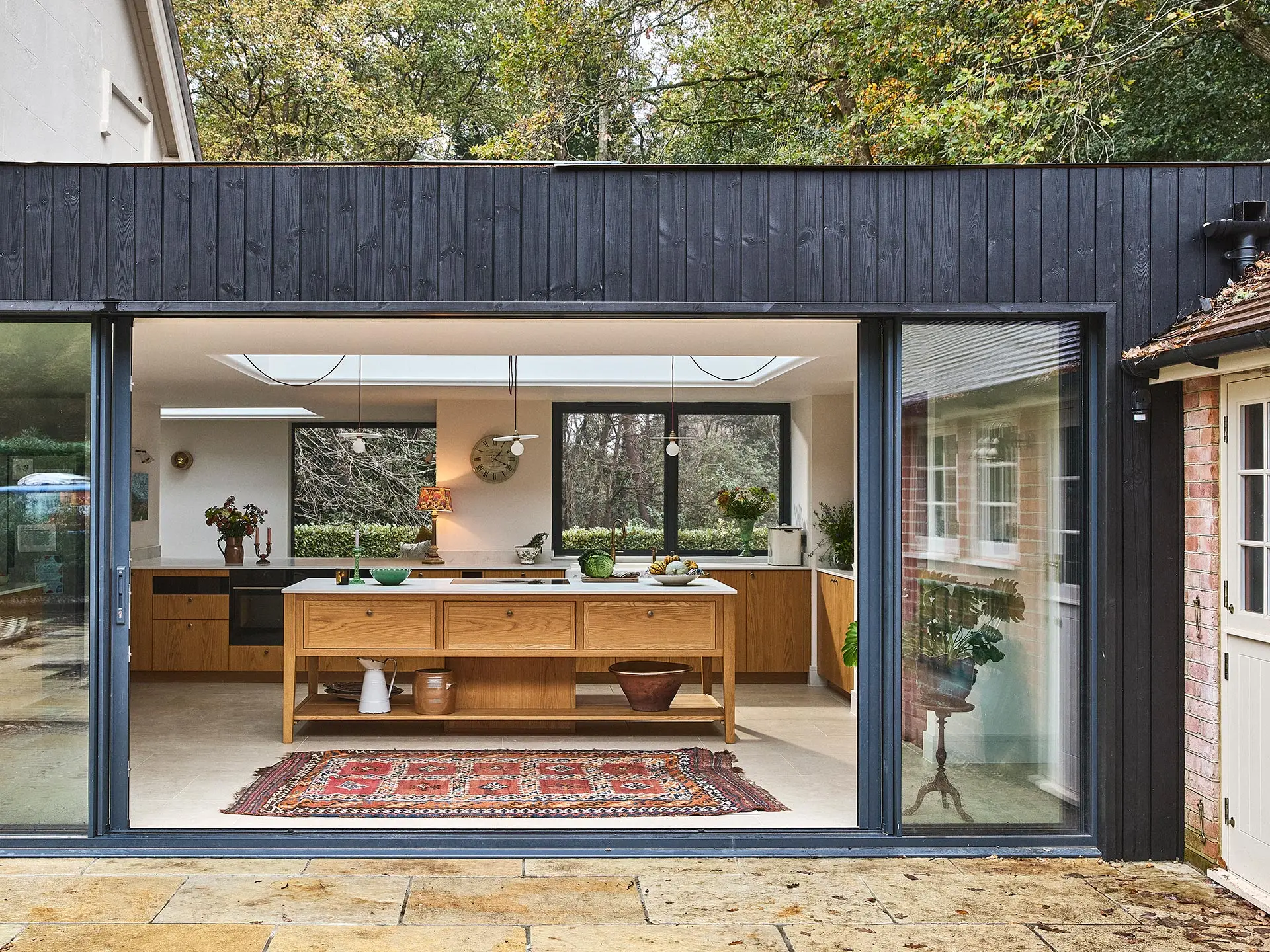 A family home in Surrey with oak wood Pluck cabinetry including a cook's table and a custom pantry cupboard.