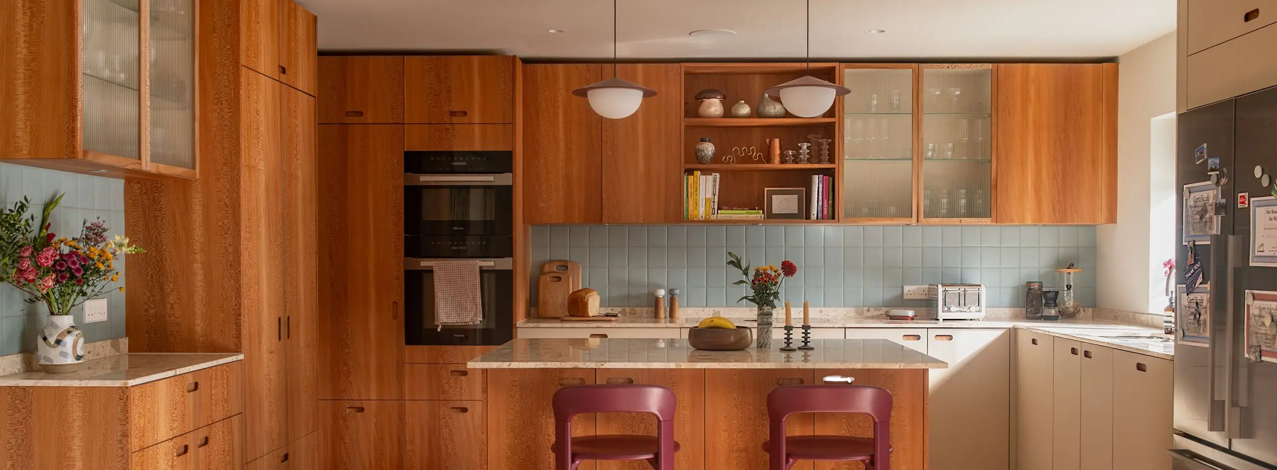 A large Pluck kitchen with London Plane wood cabinetry and an island